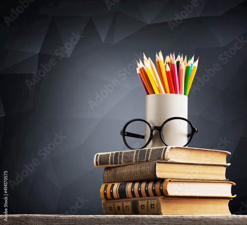 Stack of vintage books, eyeglasses and pencils, education and learning