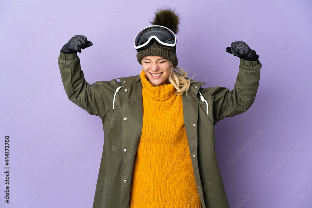 Skier Russian girl with snowboarding glasses isolated on purple background doing strong gesture Skier Russian girl with snowboarding glasses isolated on purple background doing strong gesture