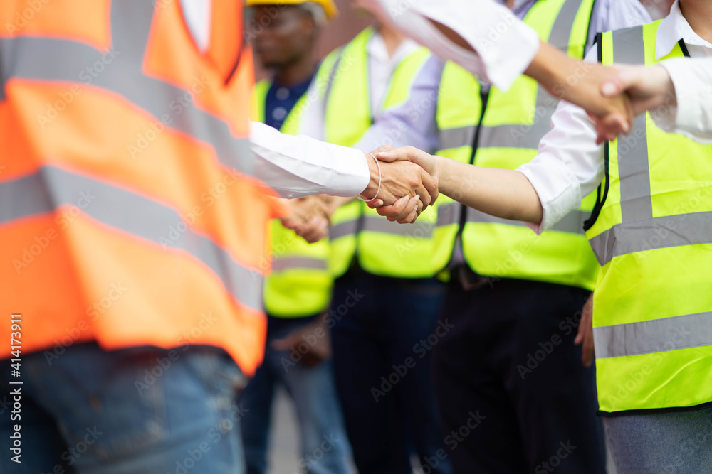 Engineers team shaking hands are congratulated on success of the work. Finishing successful meeting.