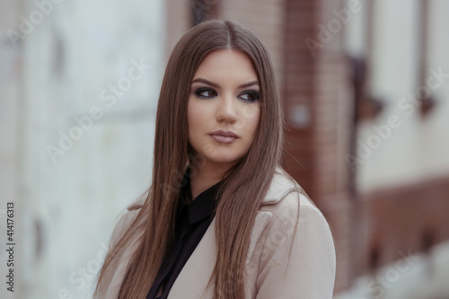Outdoor portrait of young stylish woman in camel coat in the city on a rainy day Free Download Outdoor portrait of young stylish woman in camel coat in the city on a rainy day - GFXLoad