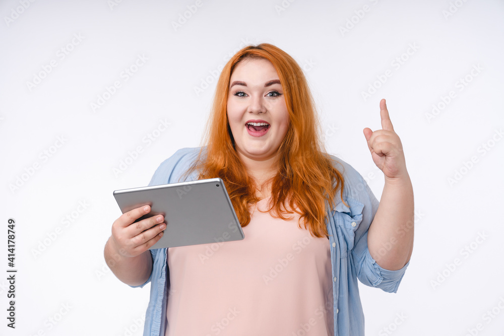 Adorable young plump woman having an idea with tablet isolated over white background Adorable young plump woman having an idea with tablet isolated over white background