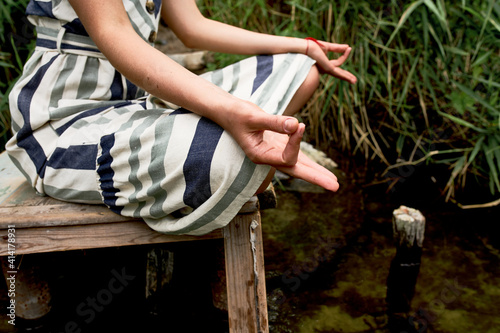Closeup of young woman meditating and practicing yoga on the nature. © ln_a