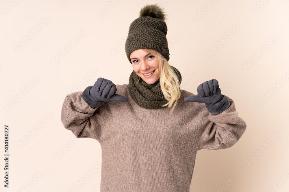Young woman with winter hat over isolated background proud and self-satisfied Young woman with winter hat over isolated background proud and self-satisfied