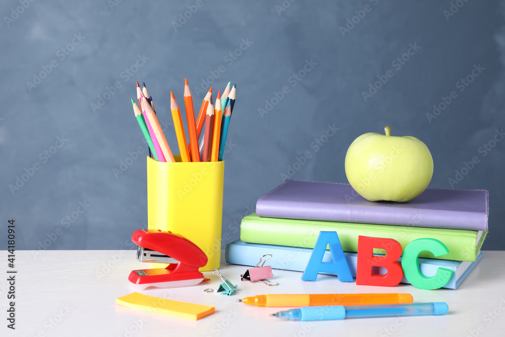 Fototapeta premium Apple and different school stationery on white wooden table