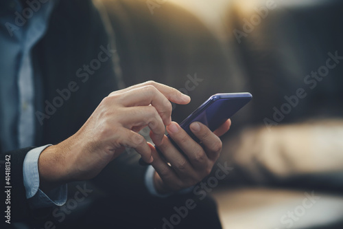 Young businessman working at the office for investment analyzing company financial report balance with smart phone. Concept for young entrepreneur and start up.