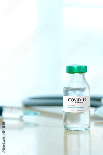 Coronavirus COVID-19 Vaccine Vials and Syringe On Reflective Surface.