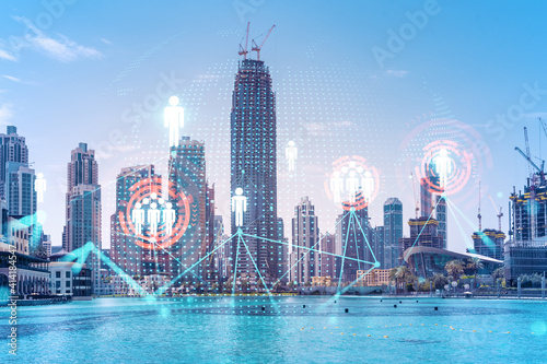Skyscrapers of Dubai business downtown. International hub of trading and financial services. Social network icons hologram, concept of people connection. Double exposure. Dubai Canal waterfront.