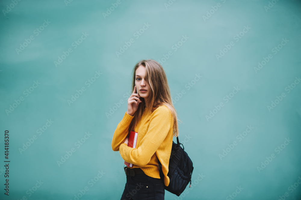 Pensive woman with backpack talking on phone Pensive woman with backpack talking on phone