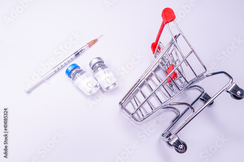 Mini shopping trolley with syringes, injections, vaccines and blood tubes on white background. Vaccination concept