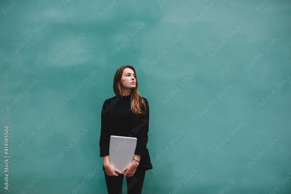 Smart female with modern laptop looking away