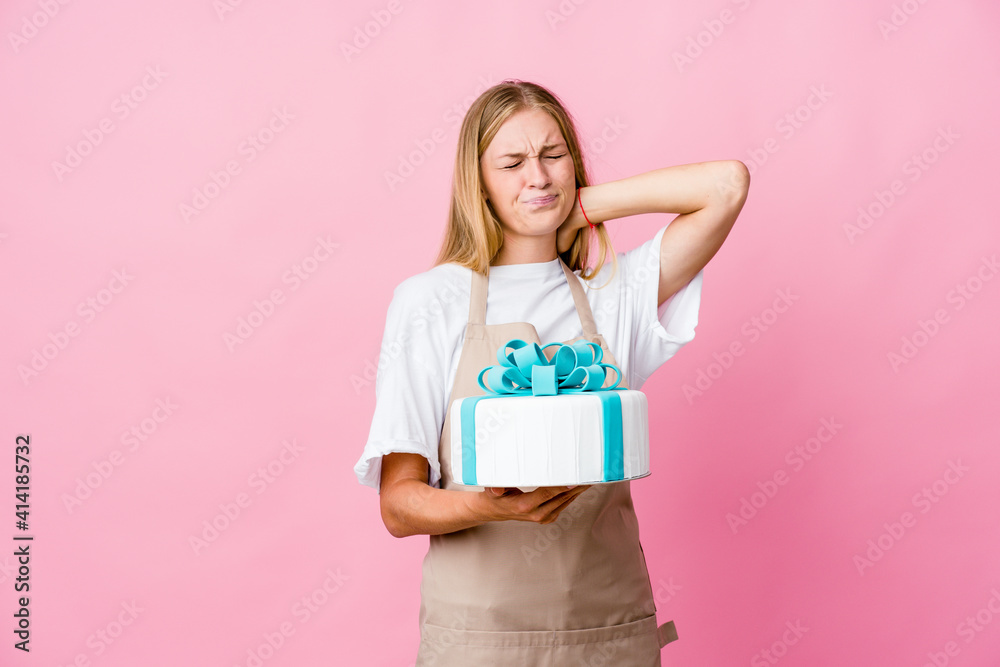 Young russian baker woman holding a delicious cake suffering neck pain due to sedentary lifestyle. Young russian baker woman holding a delicious cake suffering neck pain due to sedentary lifestyle.