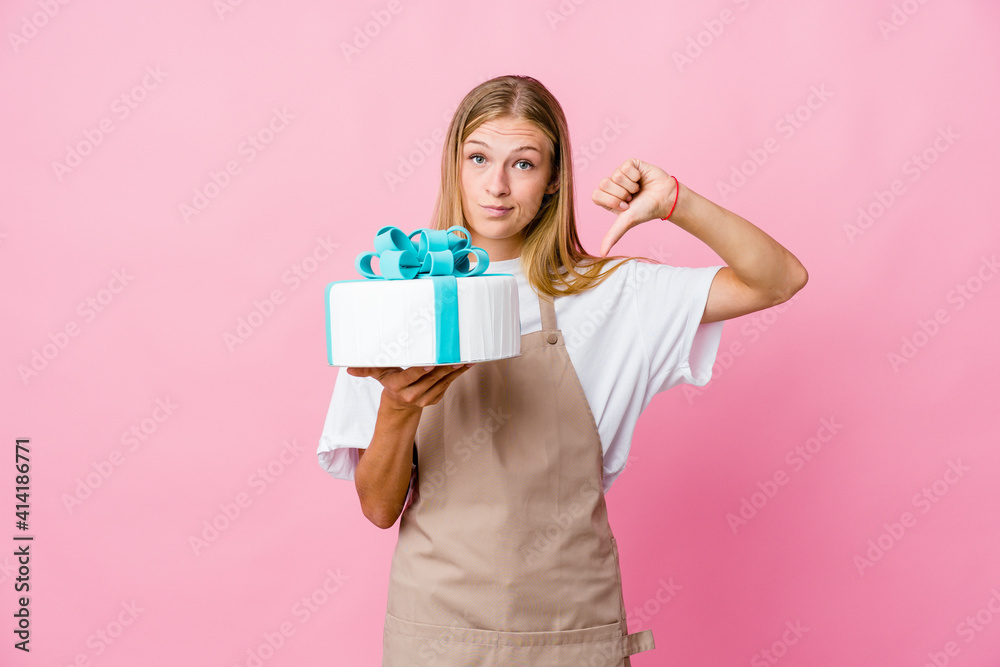Young russian baker woman holding a delicious cake showing thumbs up and thumbs down, difficult choose concept Young russian baker woman holding a delicious cake showing thumbs up and thumbs down, difficult choose concept