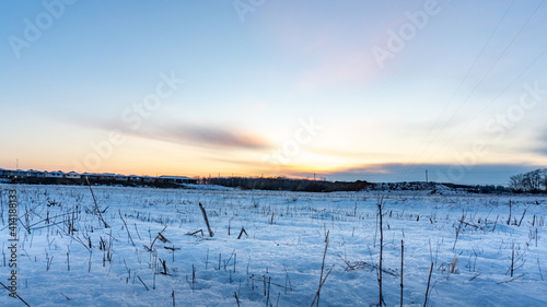 Open field covered in snow and a sunset