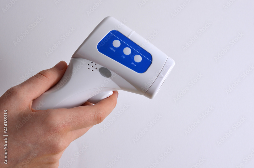 Non-contact thermometer in hands on a white background. Non-contact thermometer in hands on a white background.