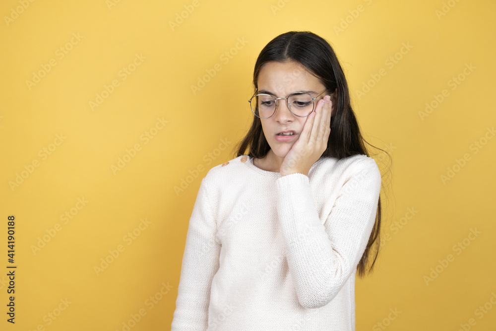 Beautiful child girl wearing casual clothes touching mouth with hand with painful expression because of toothache or dental illness on teeth