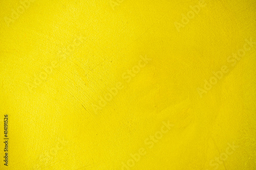 Yellow cement texture or concrete wall for the background. High resolution through a retouching process to adjust the colour of the concrete wall to yellow. Yellow plaster wall texture for background.