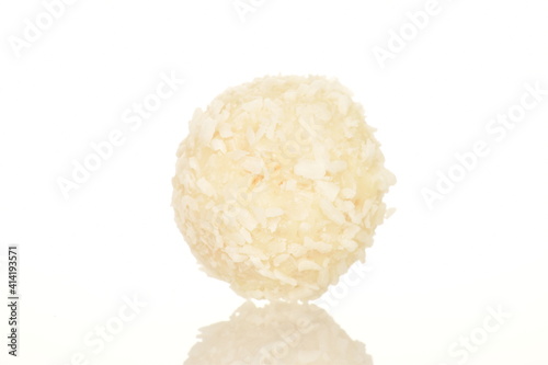 One round candy with coconut flakes, close-up, isolated on white.