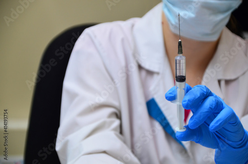 Doctor, nurse, scientist hand in blue gloves holding flu, measles, coronavirus, covid-19 vaccine disease preparing for child, baby, adult, man and woman vaccination shot, medicine and drug concept.