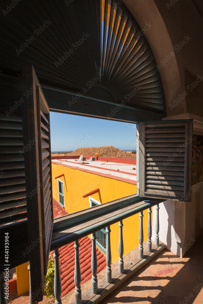 Obraz premium Cuba, Trinidad, window over plaza, shutters and shadows. Trinidad and the Valley de los Ingenios is a UNESCO World Heritage Site.