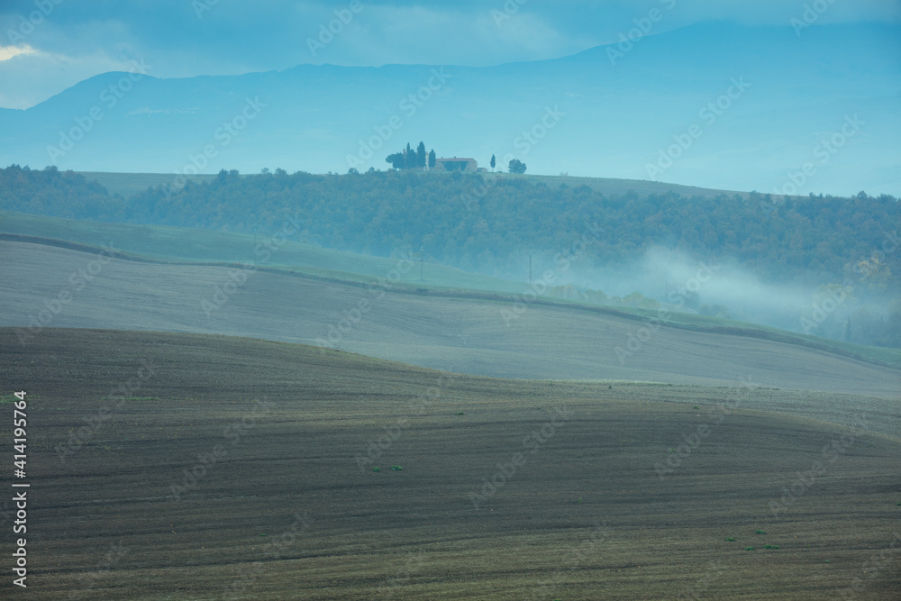 Fototapeta premium landscape with agricultural field, hills and fog