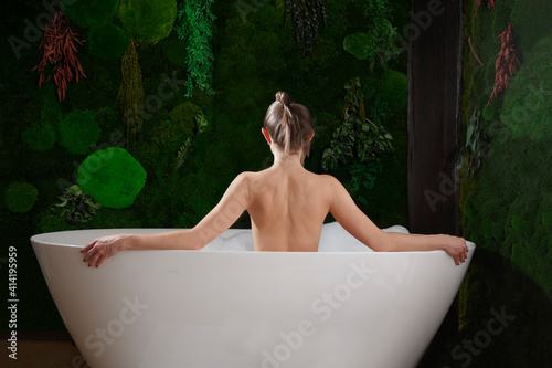 Woman relaxing in bath with tropical plants. organic skin care. Spa relaxation. Healthy lifestyle 