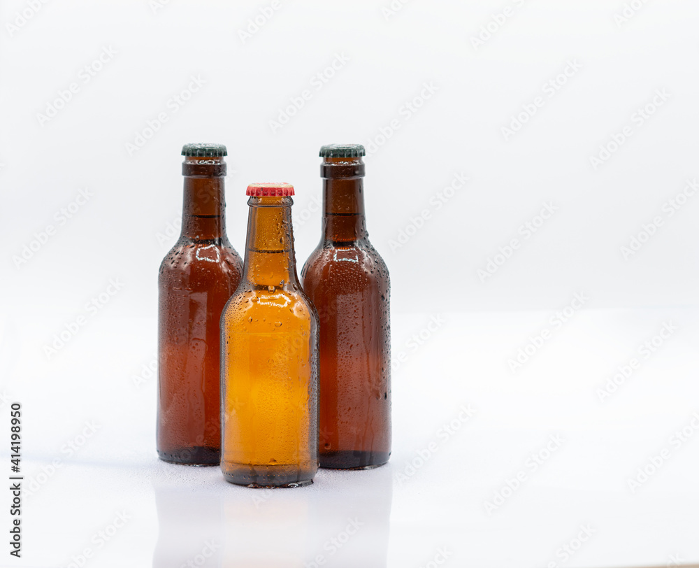 Three bottles of cold beer on white background