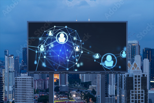 Glowing Social media icons on billboard over night panoramic city view of Kuala Lumpur, Malaysia, Asia. The concept of networking and establishing new connections between people and businesses in KL