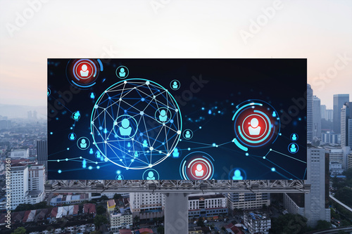 Glowing Social media icons on billboard over sunset panoramic city view of Kuala Lumpur, Malaysia, Asia. The concept of networking and establishing new connections between people and businesses in KL