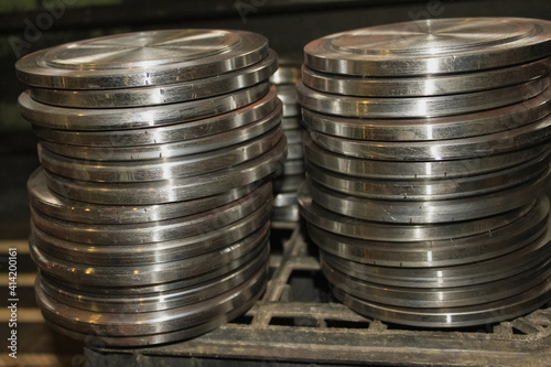Two stacks of metal pancakes are in the production warehouse