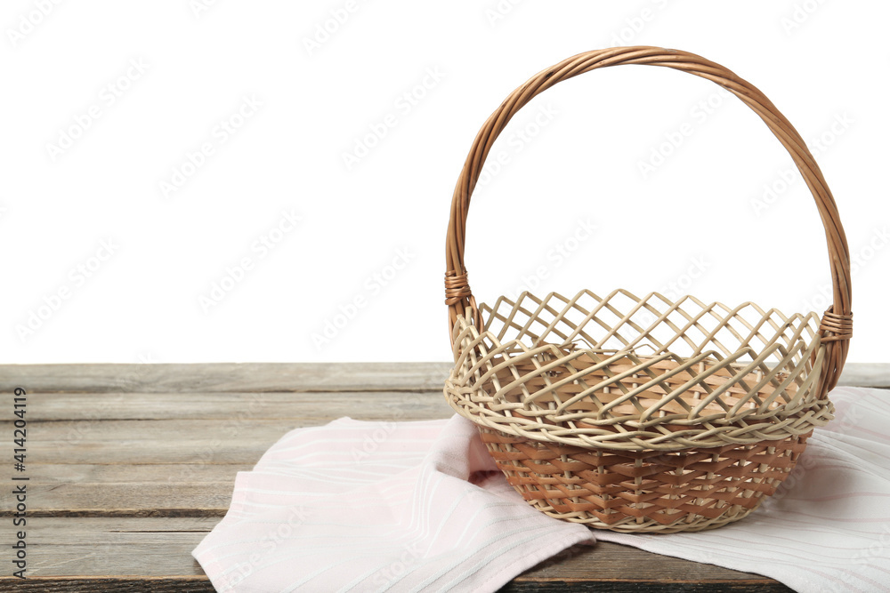 Obraz premium Empty wicker basket and cloth on wooden table against white background, space for text. Easter holiday