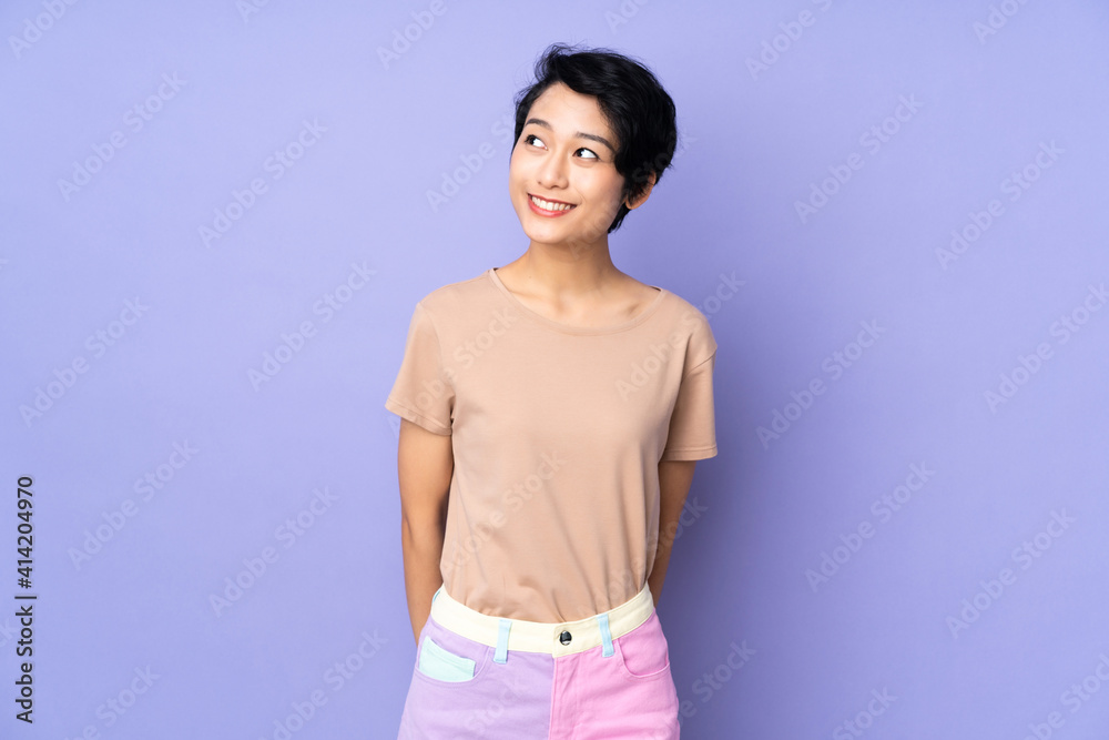 Young Vietnamese woman with short hair over isolated purple background thinking an idea while looking up Young Vietnamese woman with short hair over isolated purple background thinking an idea while looking up