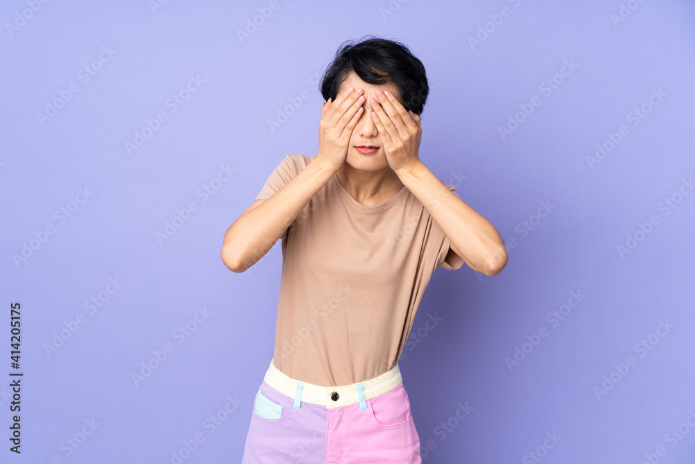 Young Vietnamese woman with short hair over isolated purple background covering eyes by hands