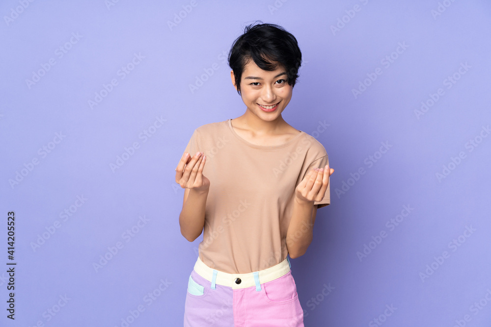 Young Vietnamese woman with short hair over isolated purple background making money gesture Young Vietnamese woman with short hair over isolated purple background making money gesture