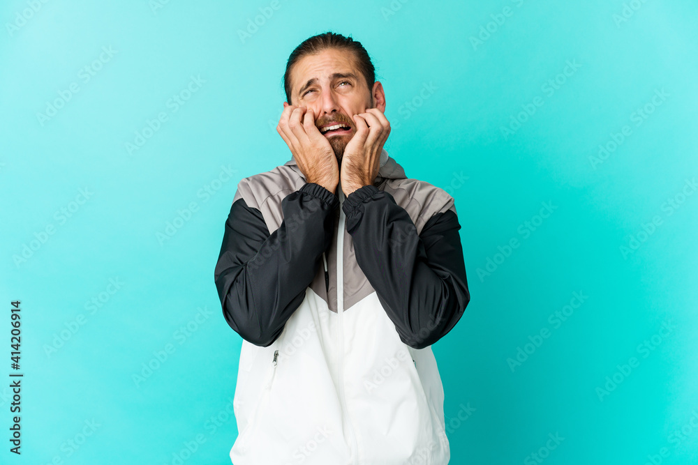 Young man with long hair look whining and crying disconsolately.