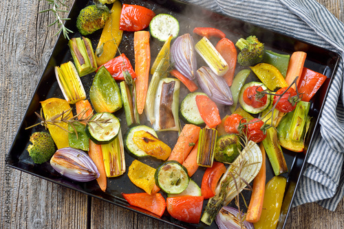 Bunt gemischtes Gemüse auf einem Backblech dampfend heiß frisch aus dem Ofen – Baked mixed colorful vegetables on a baking sheet  just coming steaming out of the oven photo