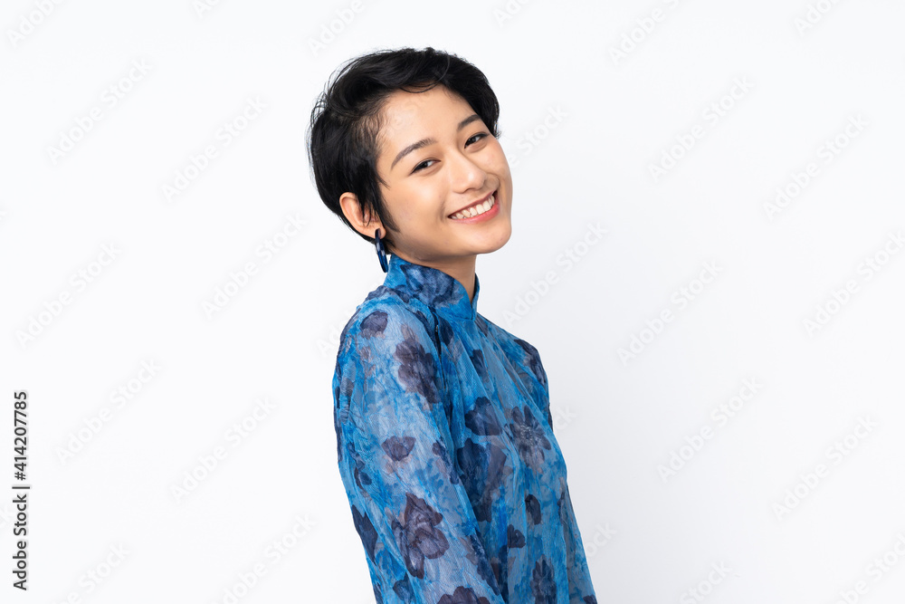 Young Vietnamese woman with short hair wearing a traditional dress over isolated white background Young Vietnamese woman with short hair wearing a traditional dress over isolated white background