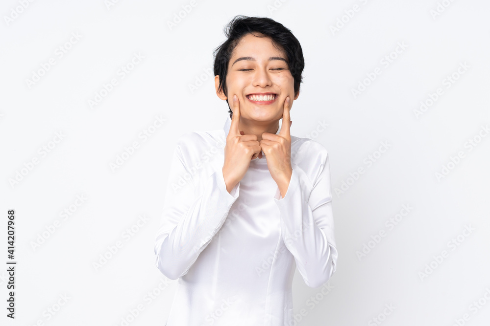 Young Vietnamese woman with short hair wearing a traditional dress over isolated white background smiling with a happy and pleasant expression Young Vietnamese woman with short hair wearing a traditional dress over isolated white background smiling with a happy and pleasant expression