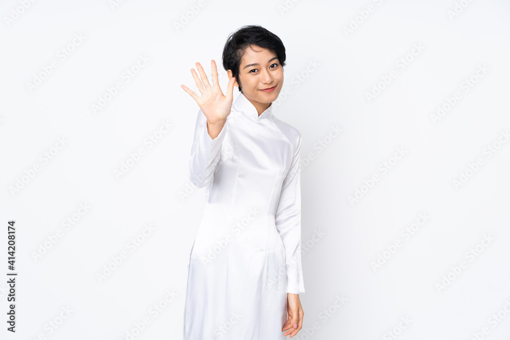 Young Vietnamese woman with short hair wearing a traditional dress over isolated white background counting five with fingers Young Vietnamese woman with short hair wearing a traditional dress over isolated white background counting five with fingers