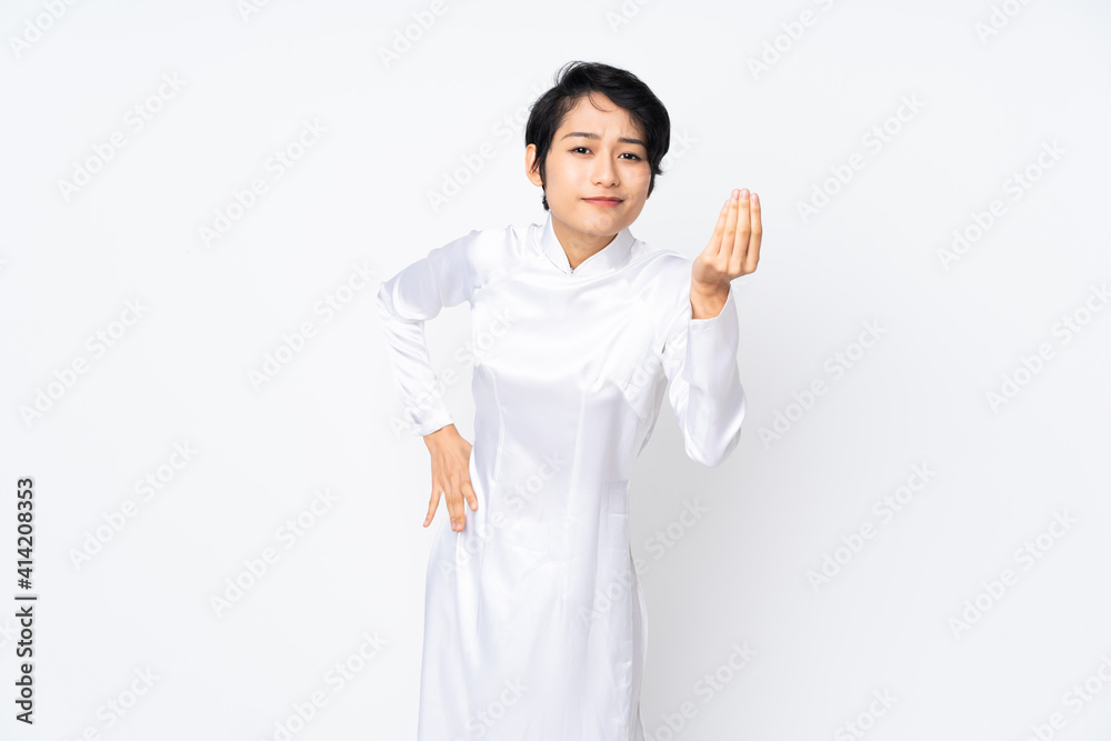 Young Vietnamese woman with short hair wearing a traditional dress over isolated white background making Italian gesture Young Vietnamese woman with short hair wearing a traditional dress over isolated white background making Italian gesture