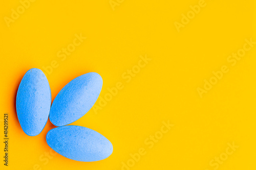 blue pills on orange yellow background