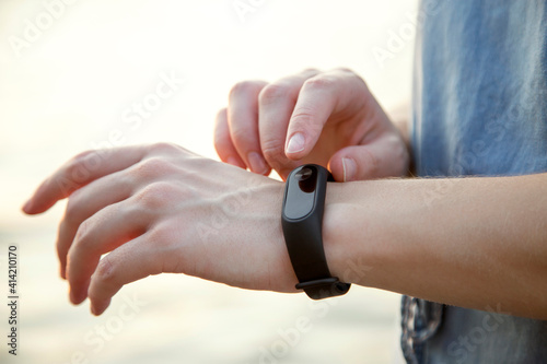 Hands of girl using smart watches outdoor. Trendy wireless technology with mobile application for fitness.