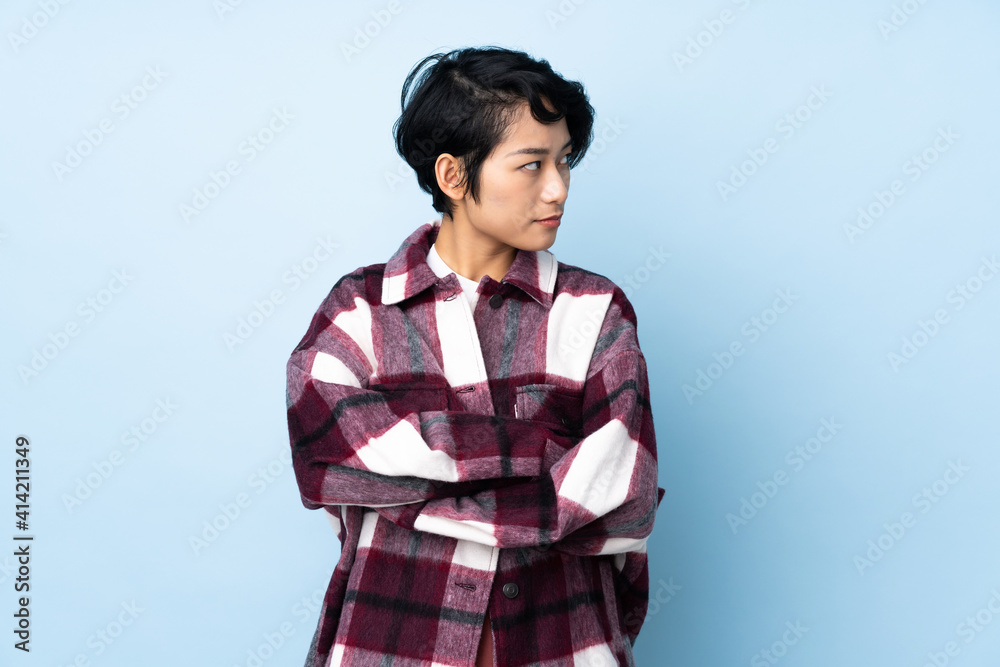 Young Vietnamese woman with short hair over isolated background keeping the arms crossed Young Vietnamese woman with short hair over isolated background keeping the arms crossed
