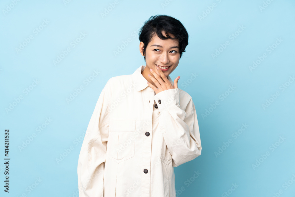 Young Vietnamese woman with short hair over isolated background looking up while smiling Young Vietnamese woman with short hair over isolated background looking up while smiling