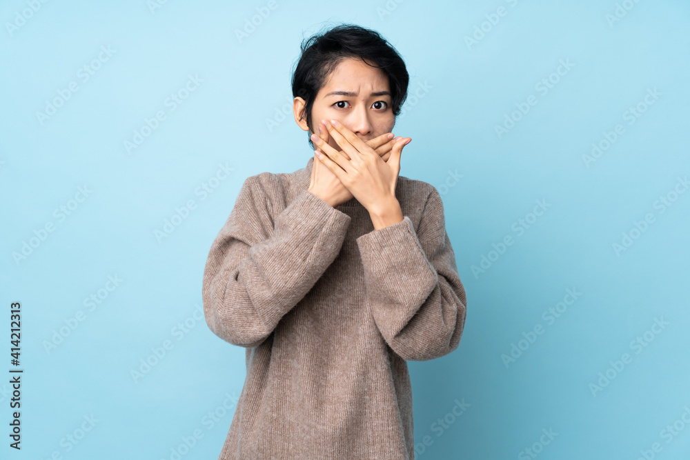 Young Vietnamese woman with short hair over isolated background covering mouth with hands Young Vietnamese woman with short hair over isolated background covering mouth with hands