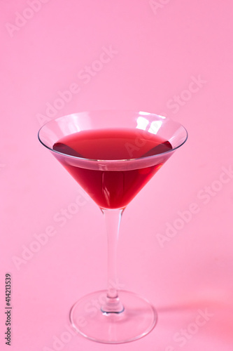 glass of red martini on pink background