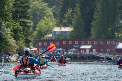 Canada, British Columbia. Sea kayakers paddle into Telegraph Cove on Johnstone Strait, Vancouver Island. photo