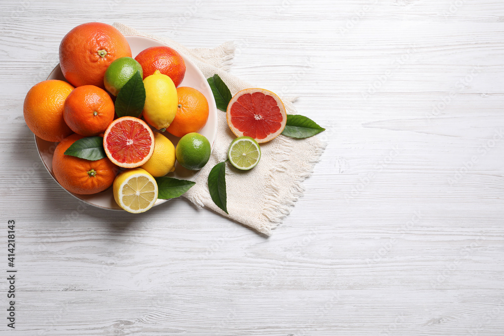 Different citrus fruits on white wooden table, flat lay. Space for text