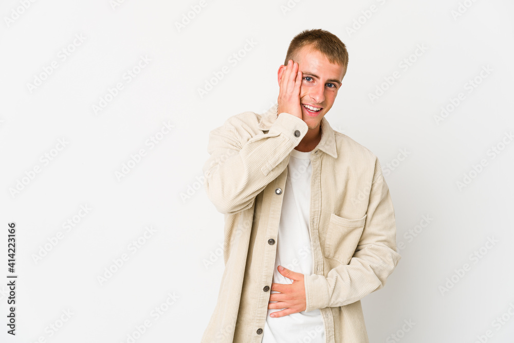 Young caucasian handsome man laughs happily and has fun keeping hands on stomach. Young caucasian handsome man laughs happily and has fun keeping hands on stomach.