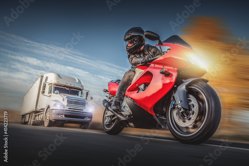 Vászonkép Motorcyclist escapes of the chase of a road truck.