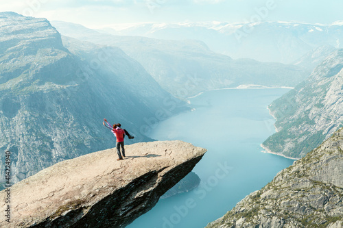 a couple of young people dancing on the trolltunga